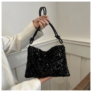 Detail of high-density black sequins and knotted tubular handle on the stylish handbag