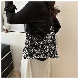 Fashionable shoulder bag featuring shimmering black and white sequins with tied leather strap