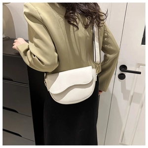 Detailed back view of a white PU leather saddle bag with a woven wide strap on model