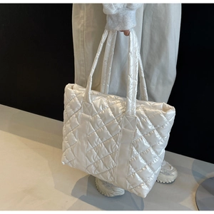 Détails de la texture matelassée du sac cabas blanc et des poignées rembourrées souples