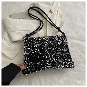 Fashionable black sequined shoulder bag with glossy texture and minimalist strap detail