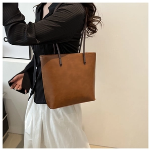 Close-up of brown PU leather tote bag showing soft texture and fine oily luster