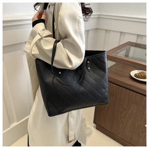 Fashionable black quilted tote bag with golden rivets and slim leather shoulder straps