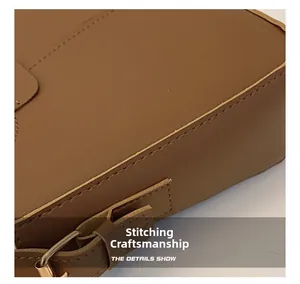 Detailed stitching craftsmanship and metallic D-ring on the brown PU leather bag