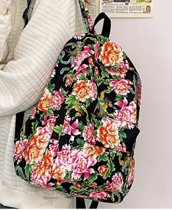 Detalle de mochila de nailon negro con estampados florales de peonía y fénix coloridos