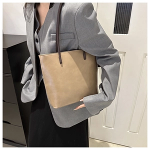 Brown PU leather tote bag styled with a grey suit for a professional commute fashion look
