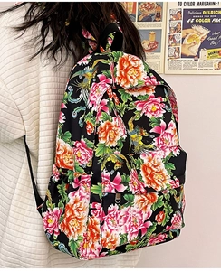 Detalle de una mochila de nailon con estampados de flores y fénix llevada por una modelo