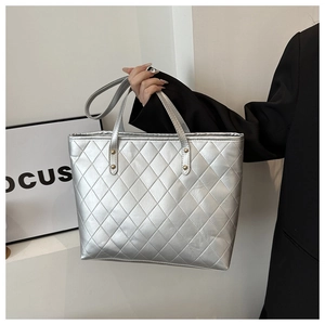 Detailed view of silver quilted tote bag with metallic finish and large diamond stitching