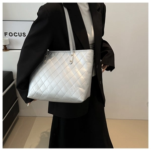 Close-up of quilted silver metallic PU leather tote bag with elegant rivet details