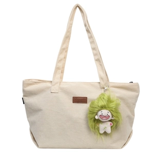 Chic beige corduroy tote bag with green plush pendant and leather patch detail