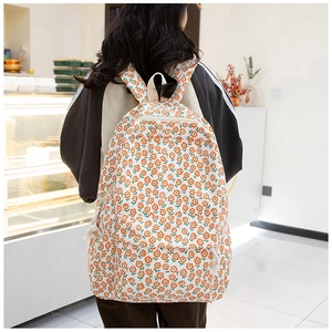Détail d'un sac à dos en tissu Oxford avec motifs floraux orange sur fond blanc
