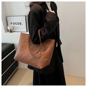 Brown quilted tote bag with diamond stitching and slim shoulder straps on a modern background