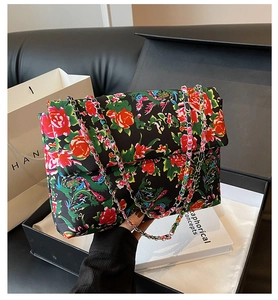Close-up of floral print fabric and silver chain strap on the vintage style crossbody bag