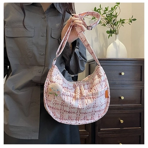 Détail du sac hobo en tweed à carreaux roses avec breloque pêche et bandoulière réglable