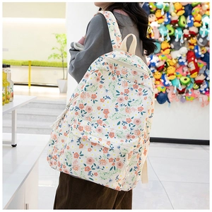 Gros plan du tissu Oxford floral avec motif de fleurs orange sur le sac à dos étudiant