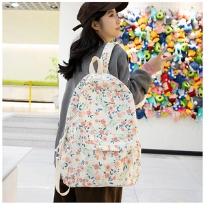 Vue détaillée du sac à dos en tissu Oxford fleuri avec motifs roses et poche avant