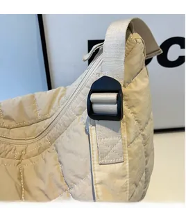 Close-up of adjustable long strap on a beige quilted nylon crossbody shoulder bag
