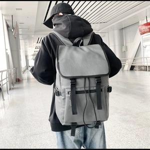Vue détaillée d'un sac à dos gris en similicuir texturé avec boucles et poche zippée