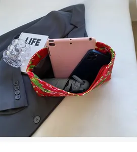 Top view showing floral canvas bag with a pink tablet, phone, and folding umbrella inside