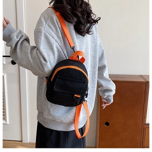 Détail du mini sac à dos en toile avec bretelles et fermetures éclair orange
