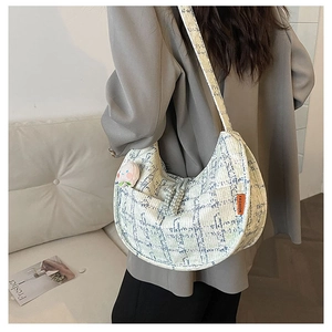 Détail du sac hobo en velours côtelé à carreaux avec étiquette et charme pêche