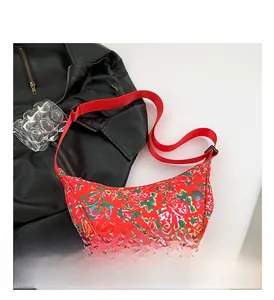 Detail view of red nylon crescent bag featuring traditional floral and dragon patterns