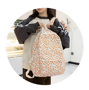 Détail d'un sac à dos en toile florale avec motifs oranges et poignées en coton doux