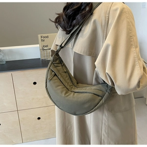 Dettaglio della borsa a mezzaluna in nylon verde oliva con tasche con zip multistrato