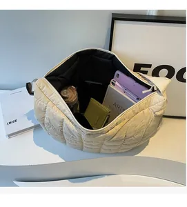 Detailed interior of a beige quilted crescent crossbody bag showing ample storage space