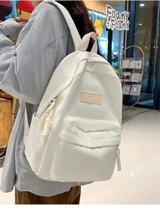 Vue latérale d'un sac à dos blanc en nylon porté par un mannequin dans un centre commercial