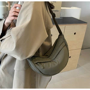 Detail view of military green crescent crossbody bag with adjustable wide fabric strap