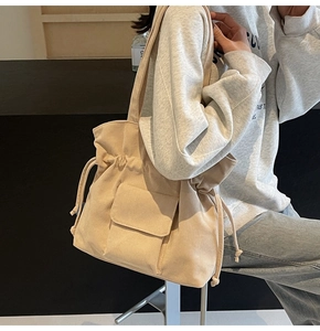 Detail of beige corduroy tote bag showing soft ribbed texture and drawstring closure design