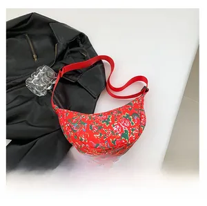 Detail of red floral crescent moon bag made of durable nylon with adjustable strap