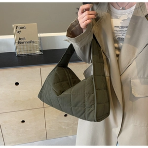 Close-up of military green quilted tote bag with diamond texture and wide shoulder strap