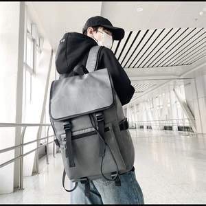 Détail d'un sac à dos en cuir PU gris avec doubles sangles à boucle à l'aéroport moderne
