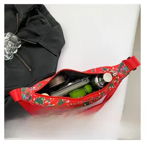 Detail view showing internal capacity of floral nylon bag with makeup and phone