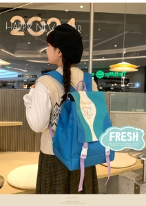 Close-up detail of stylish nylon backpack featuring color block design and side mesh pocket