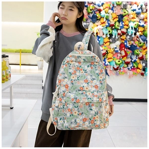 Détail du sac à dos en tissu Oxford à fleurs avec poche zippée porté par un mannequin