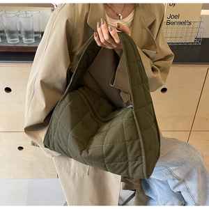 Detail of army green quilted nylon tote bag with padded handles and diamond pattern