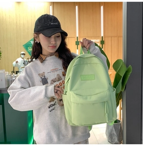 Détail d'un sac à dos en nylon vert clair avec poche zippée et rangements latéraux