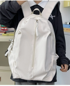 Minimalist white nylon backpack featuring a unique vertical long zipper and woven puller detail