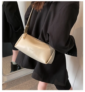 Detailed side view of beige PU leather cylindrical crossbody bag with LUKADI brand embossing