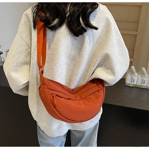 Vista dettagliata della borsa a tracolla arancione in nylon a forma di mezzaluna