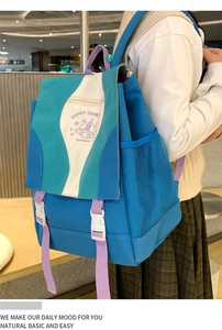 Detail of color-block nylon backpack featuring happy alien prints and buckle closure