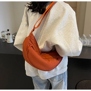 Dettaglio della borsa a mezzaluna in nylon caramello con texture e tracolla regolabile