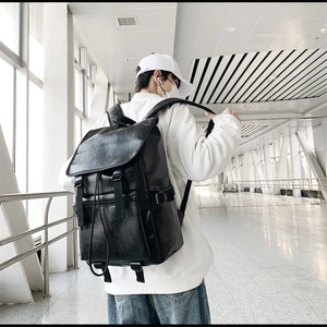 Détail d'un sac à dos minimaliste en cuir PU noir avec fermeture à rabat et sangles de côté