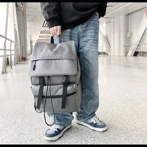 Detailed view of the grey PU leather backpack featuring metal buckles and matte texture