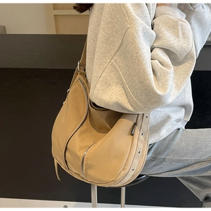 Close-up of the khaki nylon shoulder bag featuring side eyelet straps and TEYNINE label