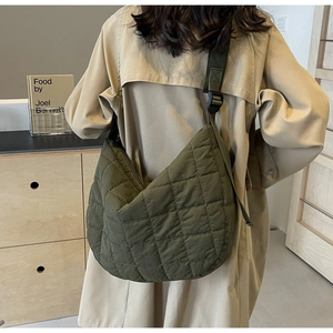 Detail view of large army green quilted crossbody bag with adjustable wide shoulder strap