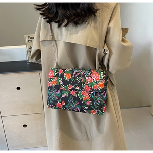 Detailed view of a vintage floral pattern crossbody bag with a metal chain shoulder strap